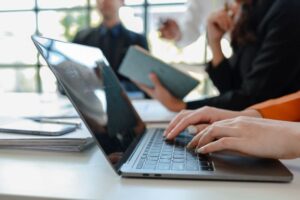 Grupo de pessoas sentadas trabalhando pelo notebook