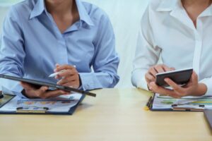 Duas pessoas sentadas a uma mesa cada uma com um tablet