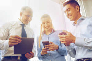 Grupo de funcionários sorridentes olhando o celular